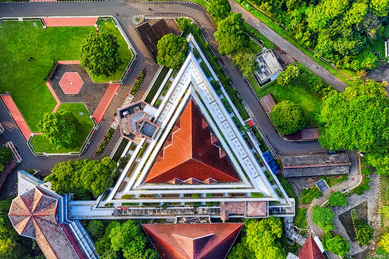 Stunning aerial view of the unique triangular architecture at Bogor Agricultural University, highlighting its vibrant red roofs and lush surroundings.
